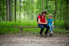 Mama en kind op een bankje in het bos