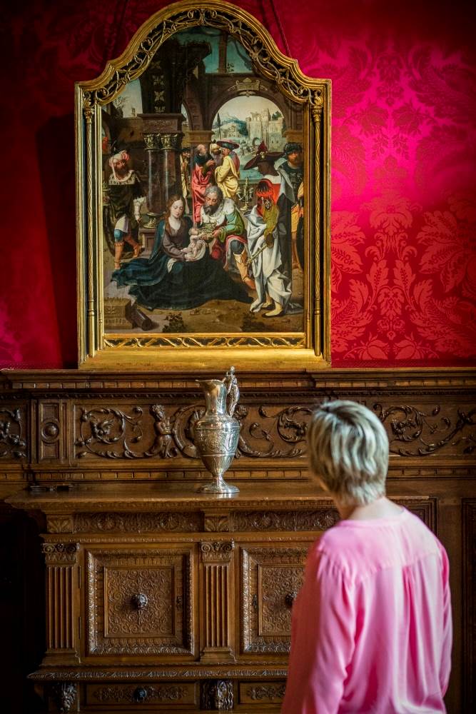 Vrouw kijkt naar schilderij van madonna met kind