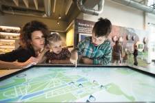 Vrouw met kinderen aan infopaneel in bezoekerscentrum Warandepoort Tervuren
