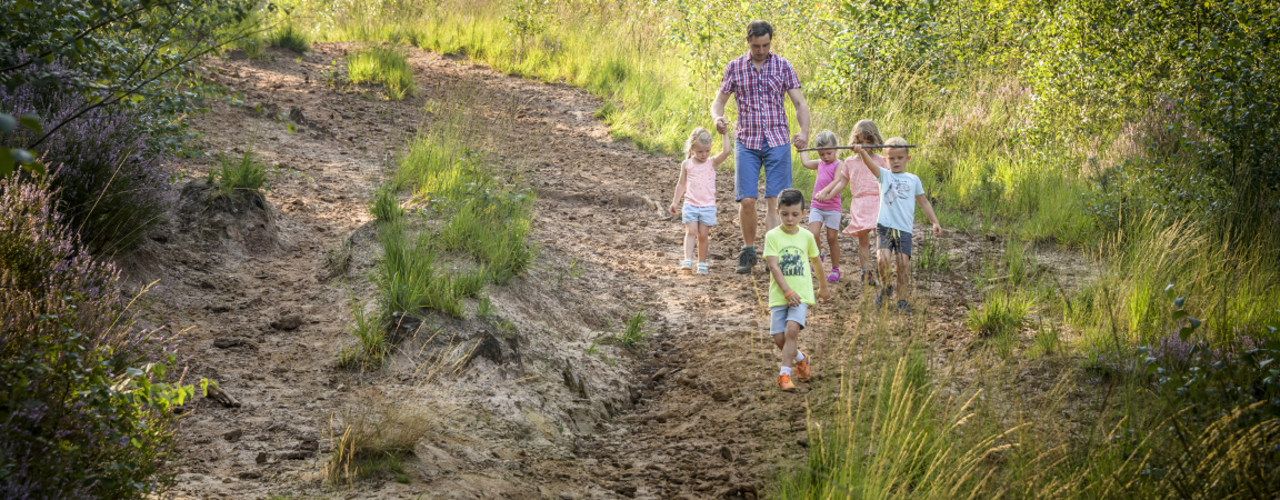 Familie met kinderen wandelt door natuurgebied Kruisheide