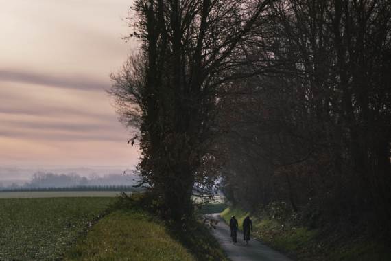 Twee fietsers in holle weg in een mistig landschap
