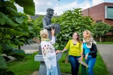 Drie vrouwen onder het standbeeld van de witloofboer in Kampenhout